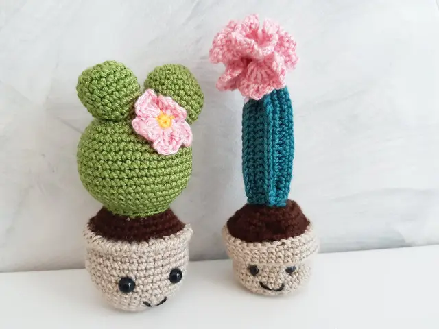 Dos cactus de crochet verdes con flor rosa y maceta tejida, sobre fondo blanco
