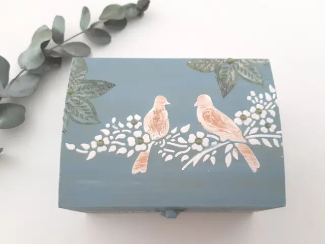 Caja de madera pintada en azul grisáceo con dos pájaros en decoupage sobre la tapa