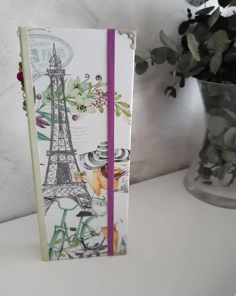 Porta tratados forrado con papel de París y Torre Eiffel, con goma azul, junto a eucalipto