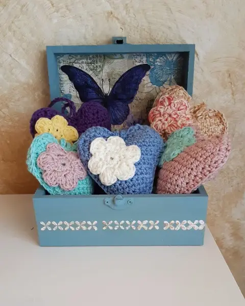 Corazón colgante de crochet en tonos azules con su cordón, sobre fondo claro