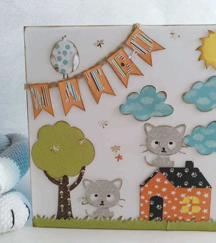 Cuadro infantil de cartulina con gatitos, casitas y guirnalda de banderines en tonos pastel