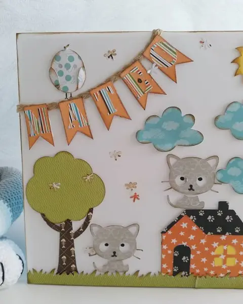 Cuadro infantil de cartulina con gatitos, casitas y guirnalda de banderines en tonos pastel