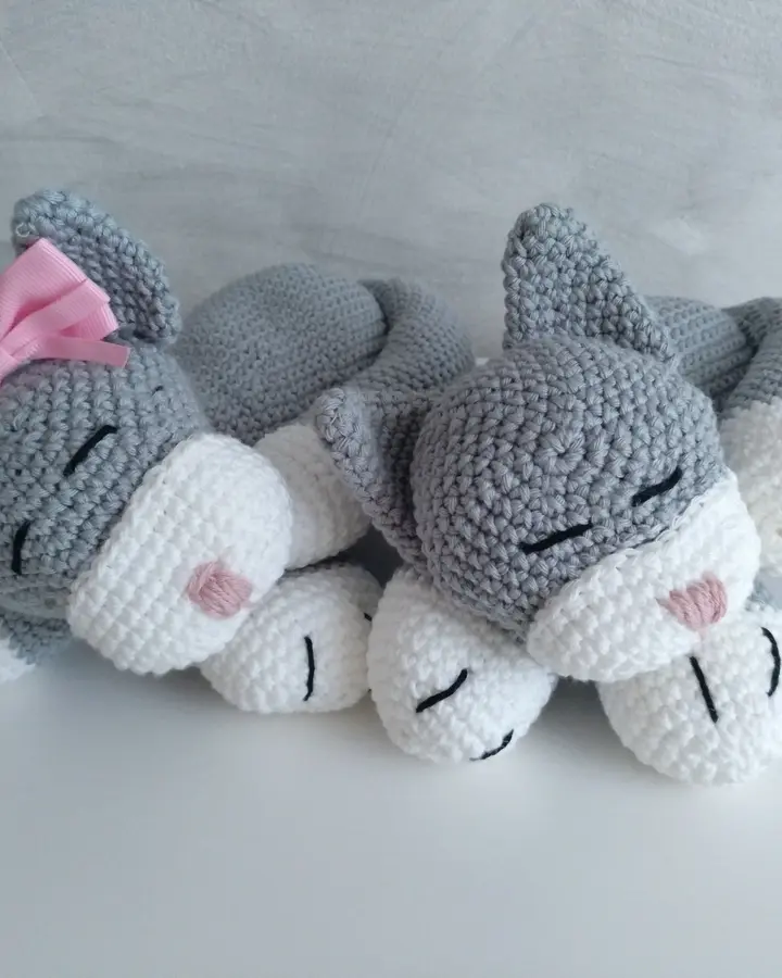 Pareja de gatitos amigurumi grises dormidos con lazos, tejidos a crochet