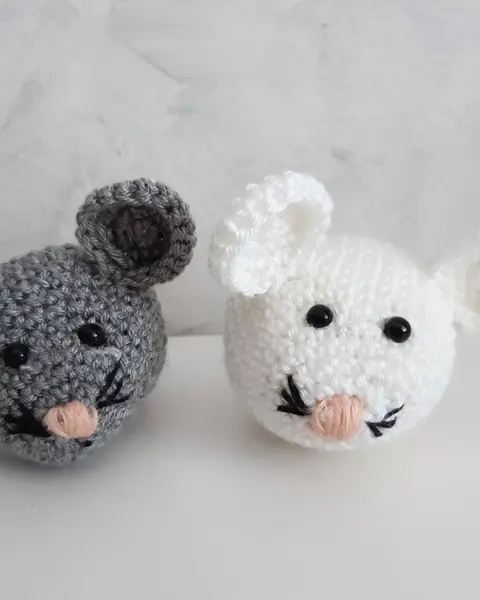 Dos ratones amigurumi, uno gris y otro blanco, tejidos a crochet