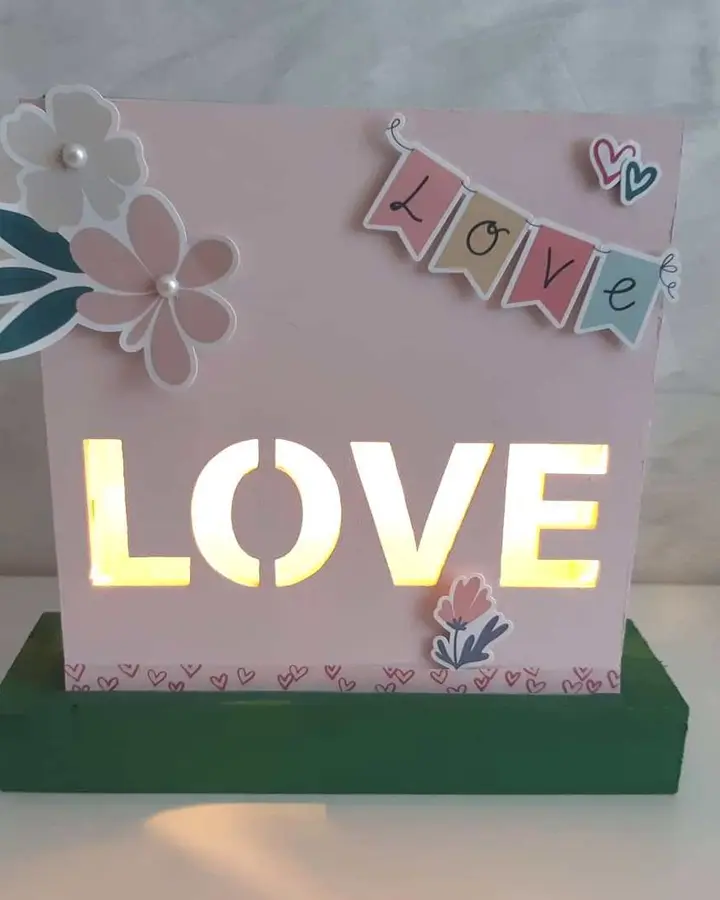 Detalle del lateral de la lámpara de madera Love con papel decorado y brillantes