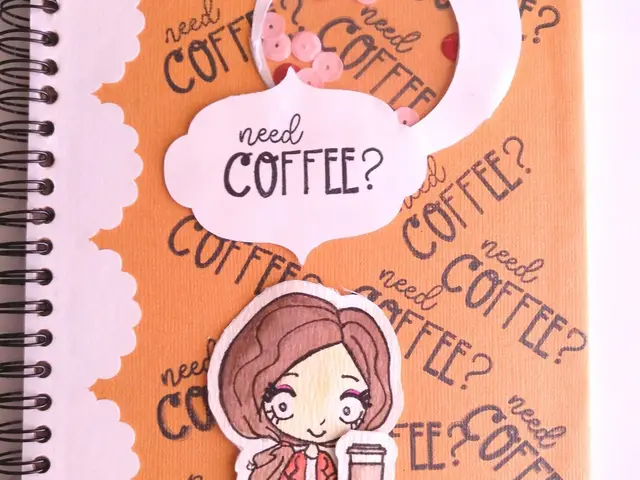 Libreta de anillas con portada naranja de café, sellos recortados a mano y una figurita con taza