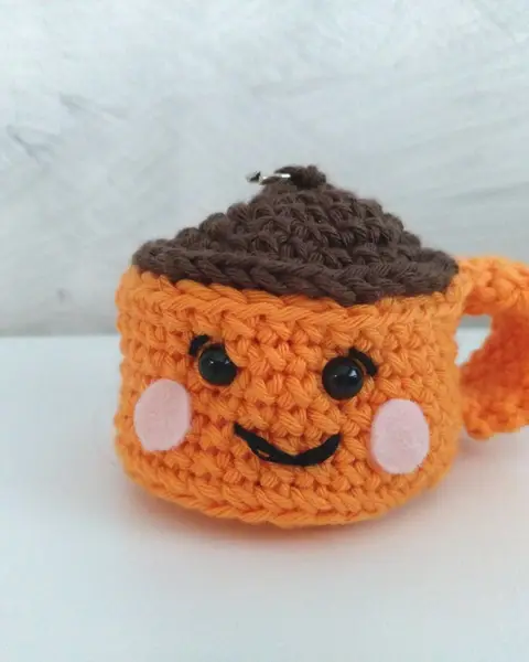 Llavero de crochet con forma de taza de café naranja con carita sonriente y espuma marrón