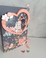 Mini álbum de boda de scrapbooking con portada azul marino, flores coral y ventana en forma de corazón