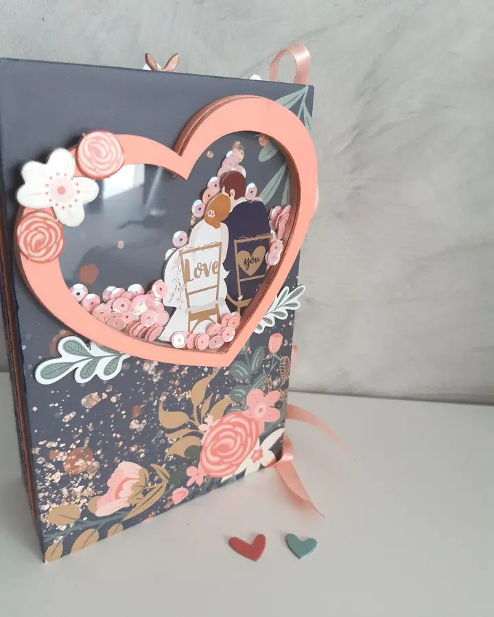 Mini álbum de boda de scrapbooking con portada azul marino, flores coral y ventana en forma de corazón