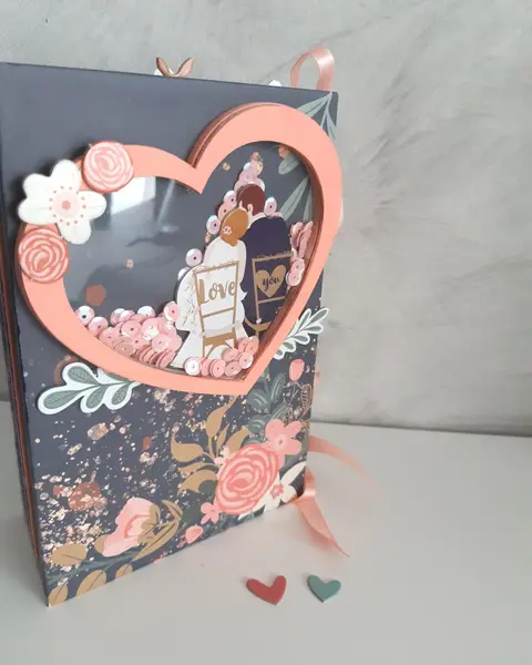 Mini álbum de boda de scrapbooking con portada azul marino, flores coral y ventana en forma de corazón