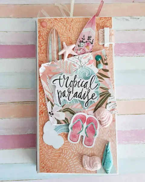 Mini álbum de scrapbooking surfero con portada de rayas pastel, tabla de surf y letrero tropical paradise