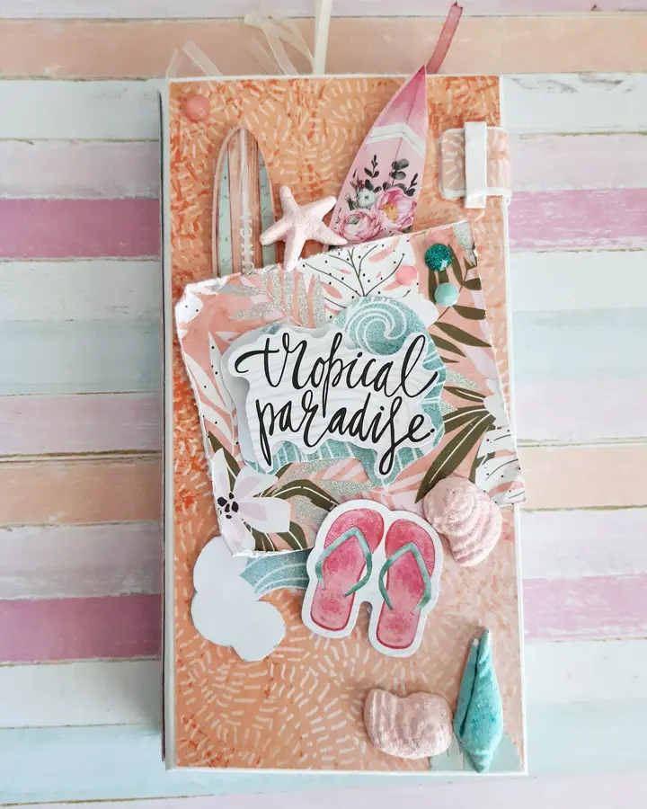 Mini álbum de scrapbooking surfero con portada de rayas pastel, tabla de surf y letrero tropical paradise